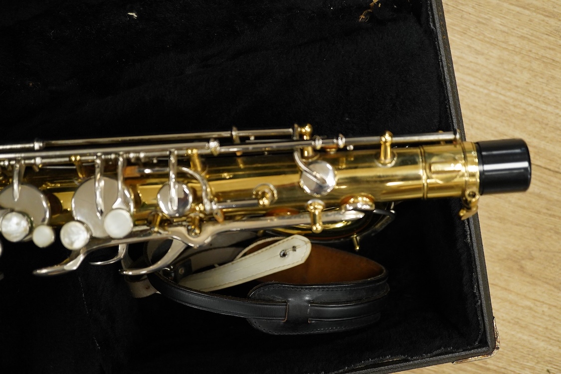 A cased Buescher Aristocrat tenor saxophone and stand